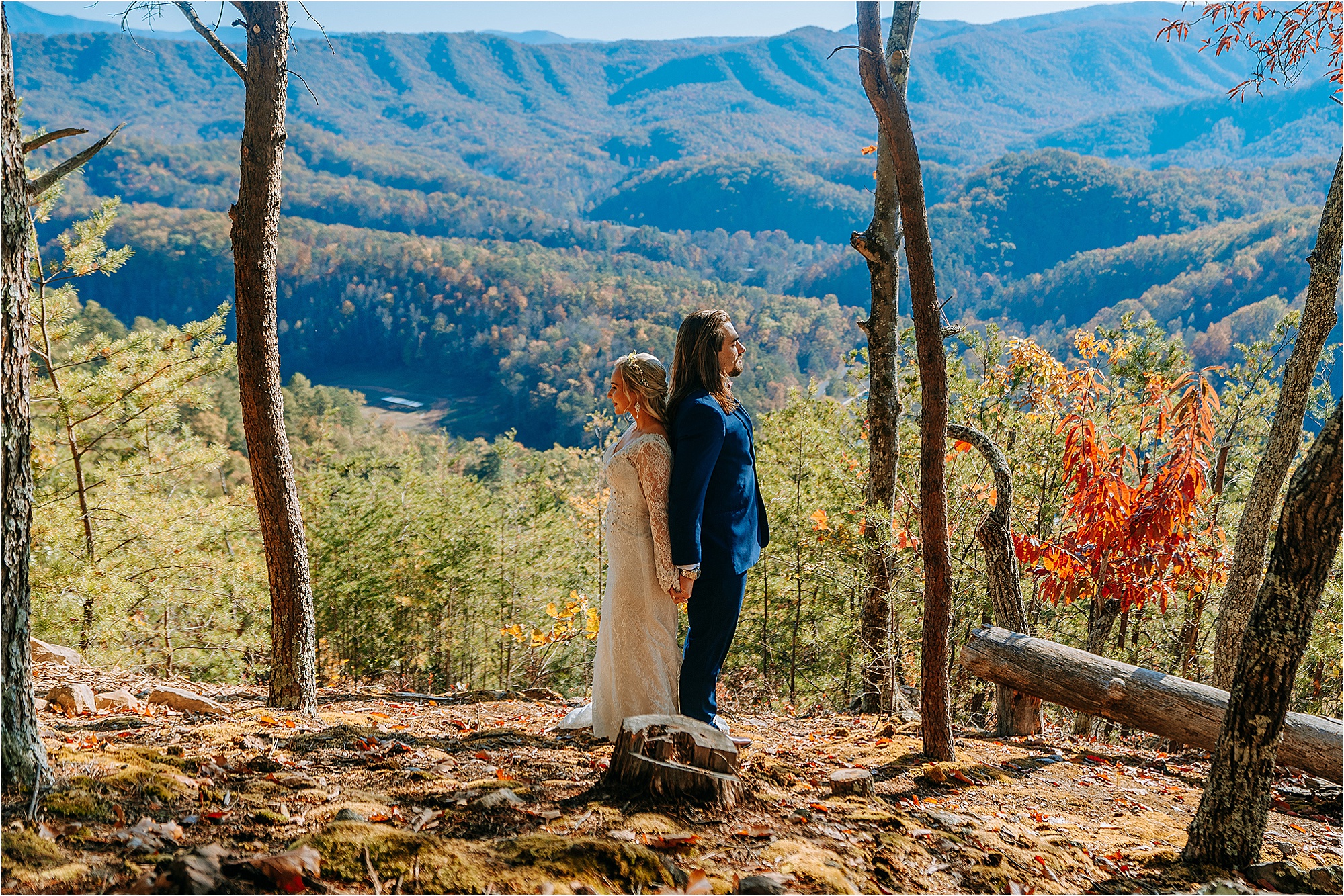 bride and groom standing back to back on mountaintop