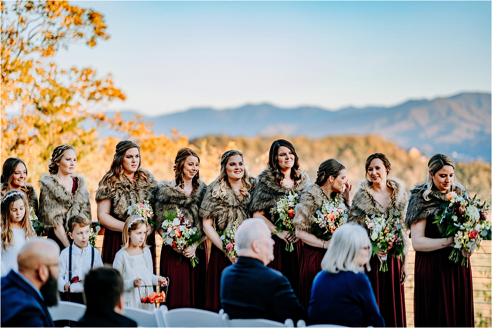 bridesmaids in burgundy dresses with faux fur