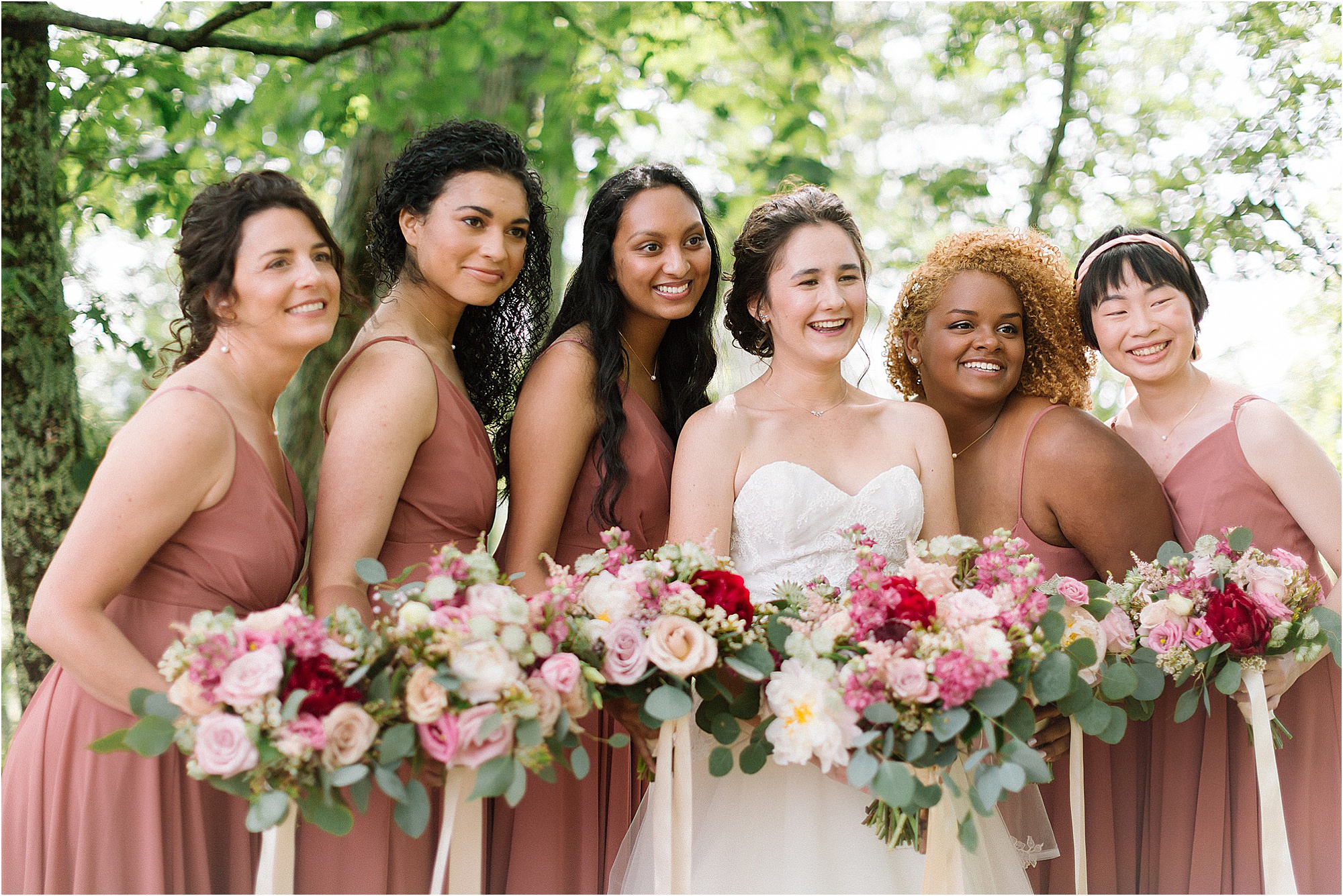 bride with bridesmaids in light pink wedding dresses