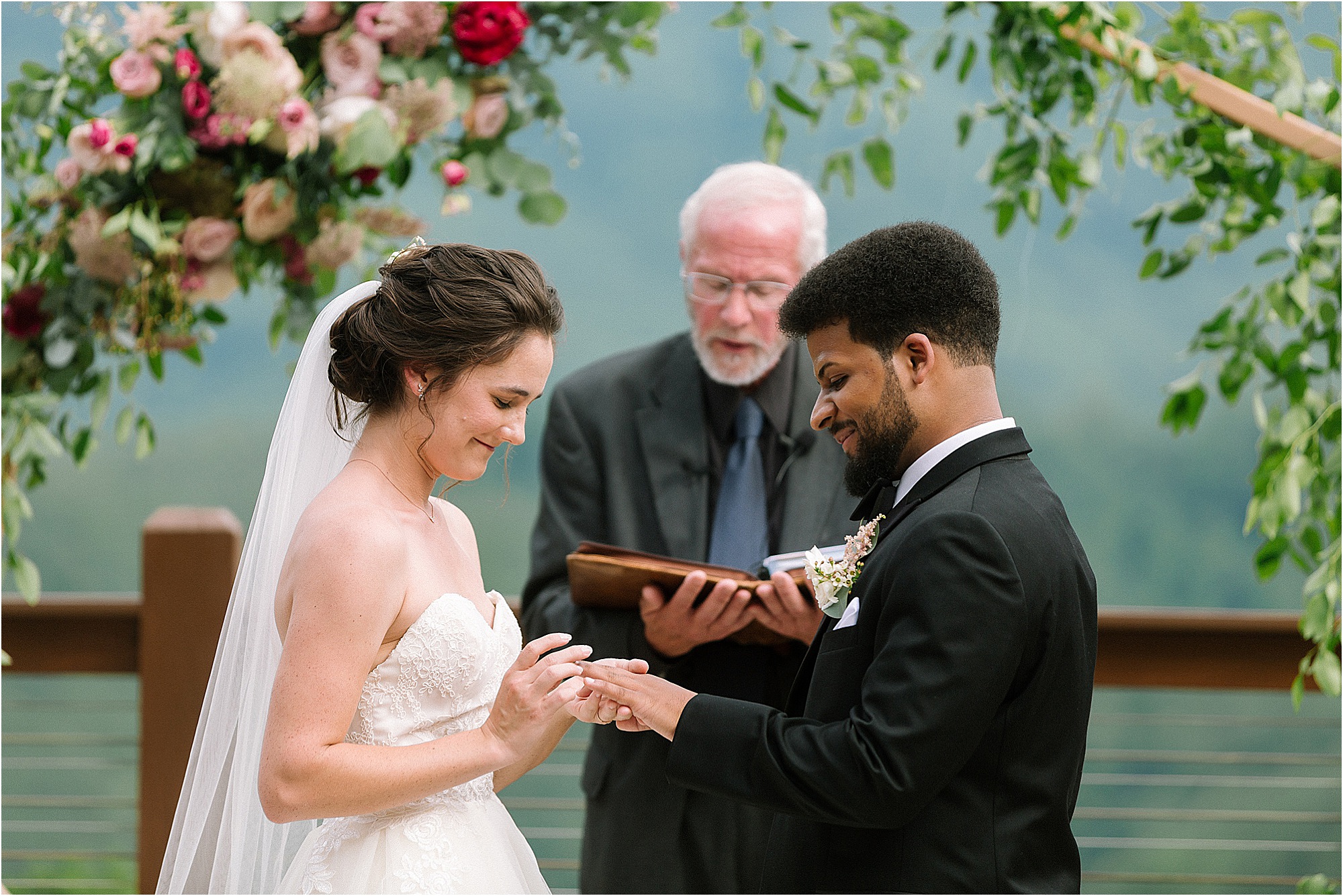 bride and groom exchange rings at wedding ceremony on mountaintop