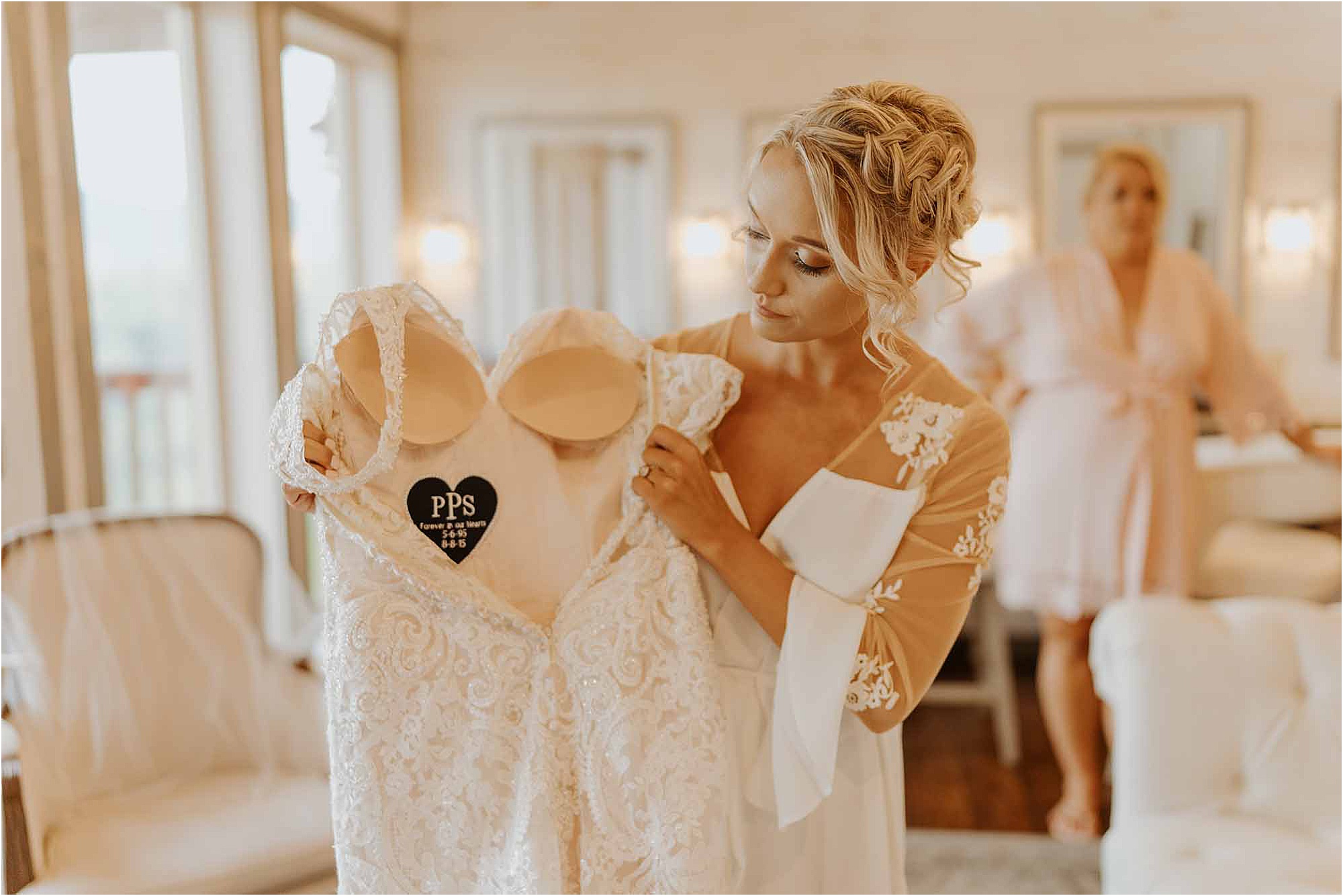 bride holding up wedding dress with stitched heart inside