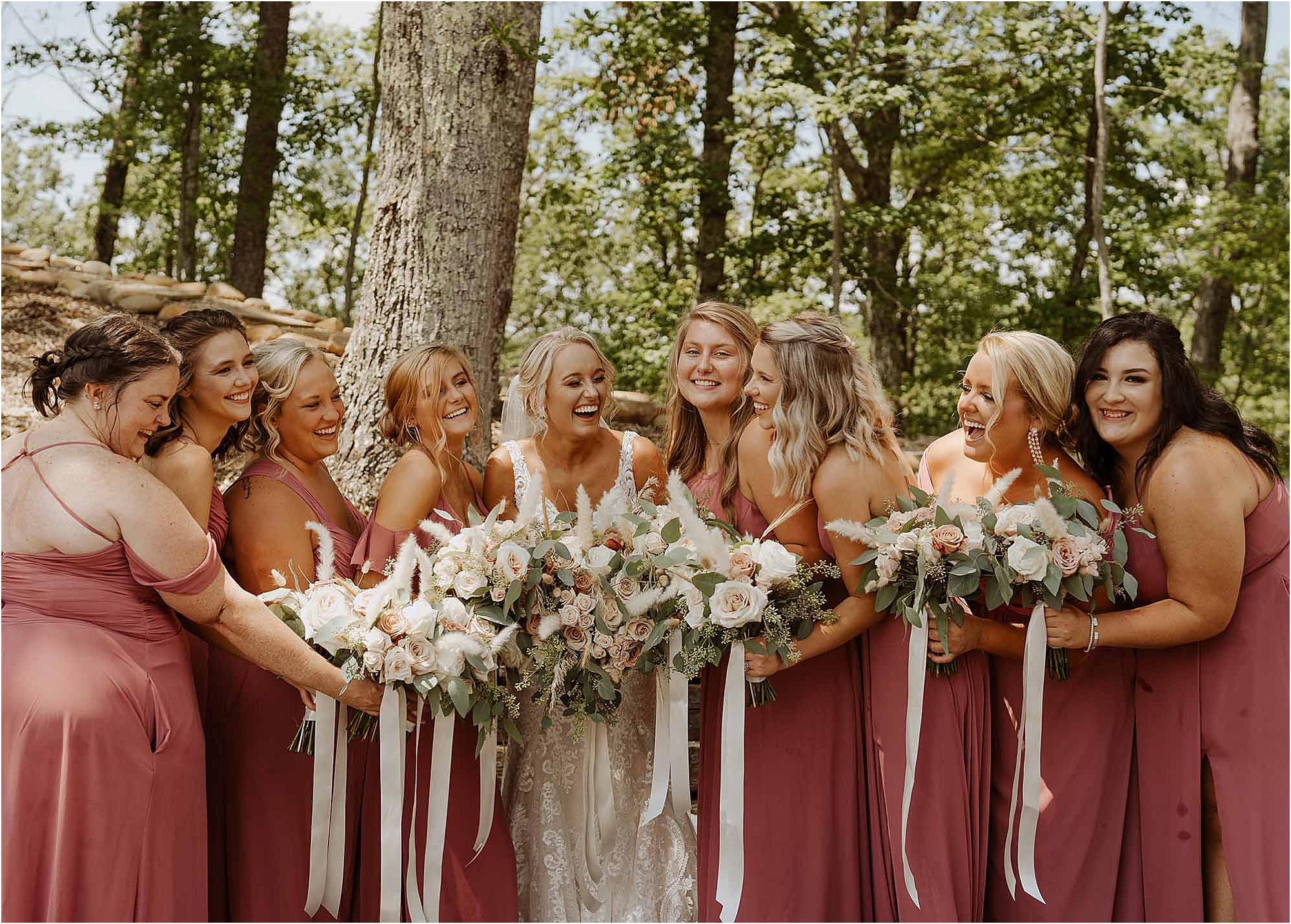 bride and bridesmaids laughing while holding bouquets