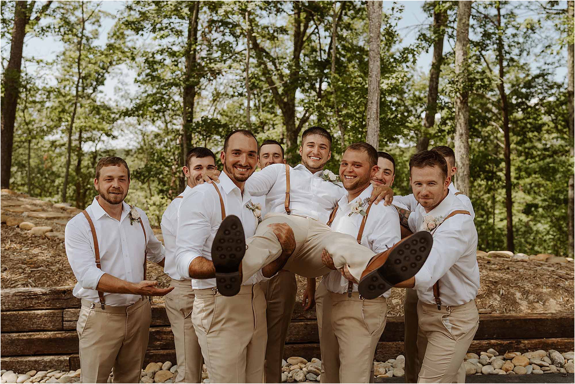 groomsmen holding up groom