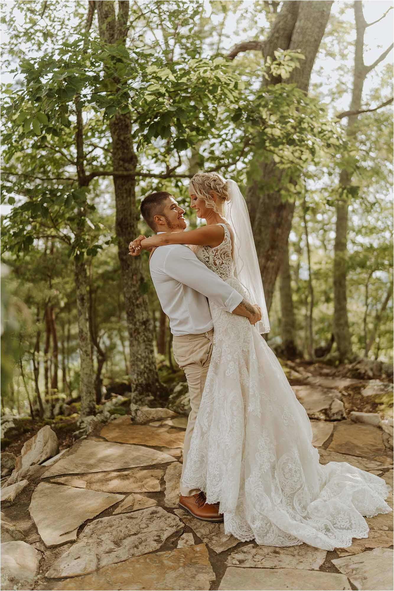 groom lifting up bride in woodland scene