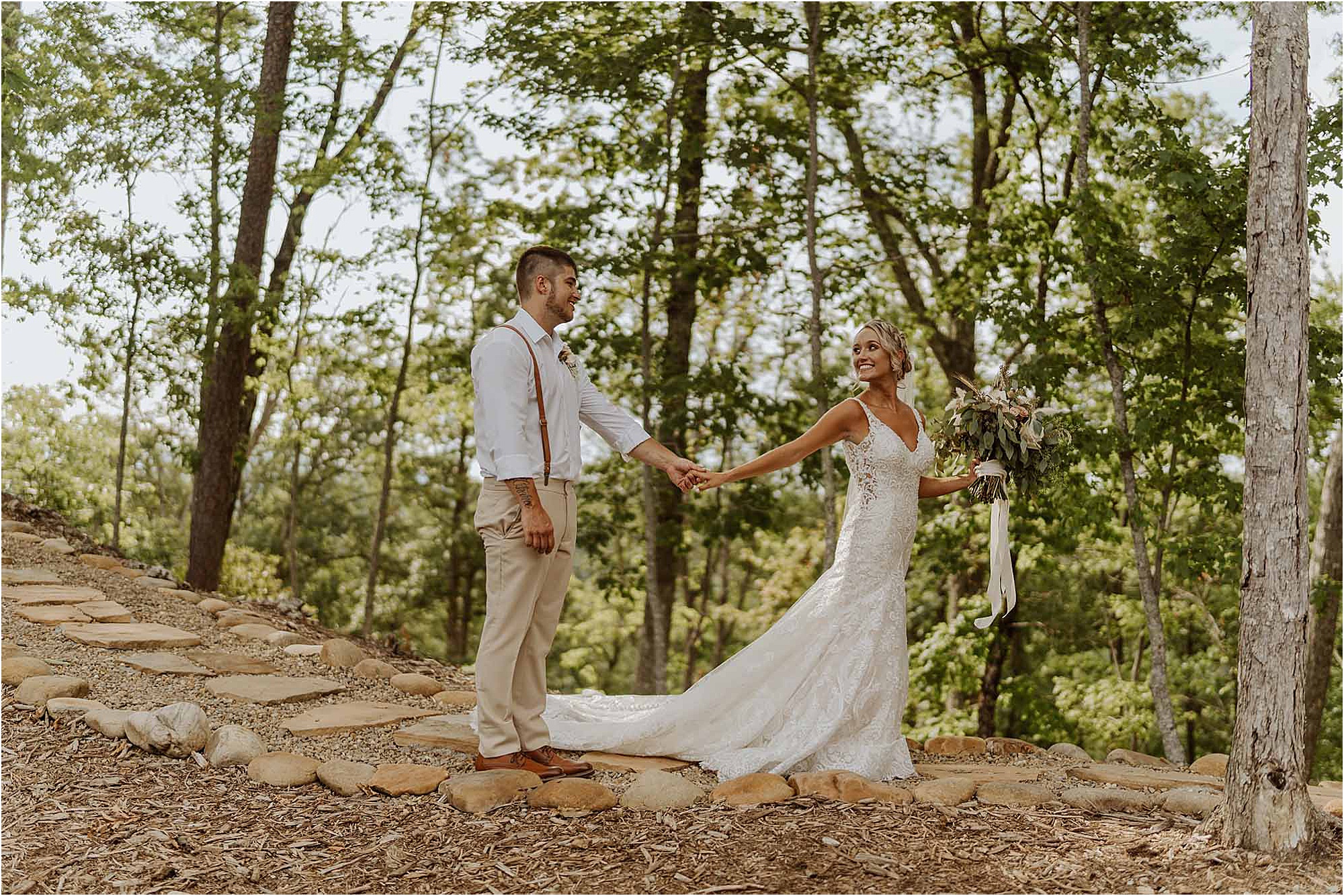 bride leading groom down forest path