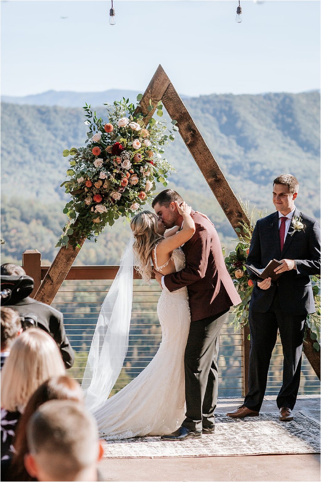 bride and groom first kiss at sun-kissed wedding ceremony