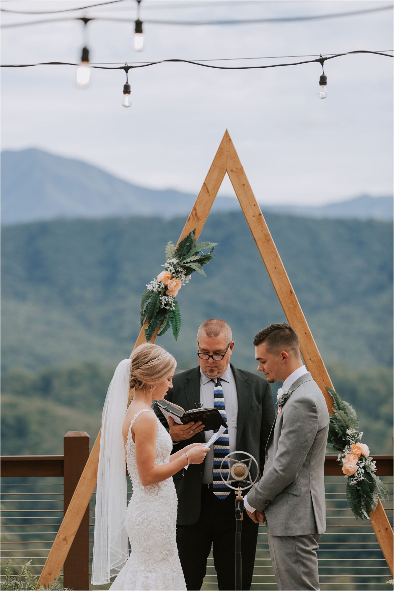 bride says wedding vows in front of triangle wedding arbor