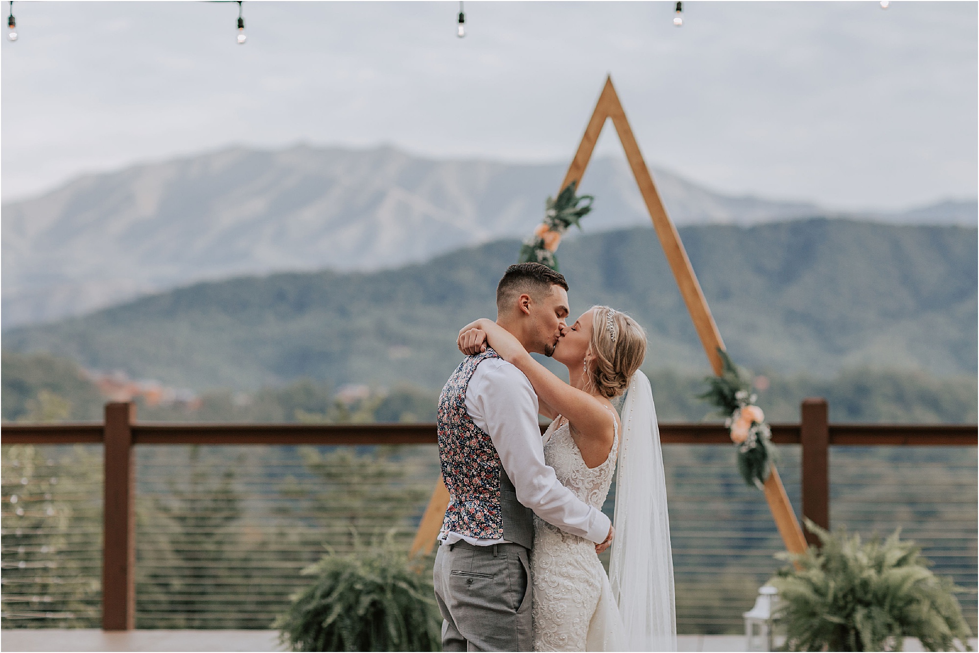 bride and groom dance in front of triangle wedding arbor