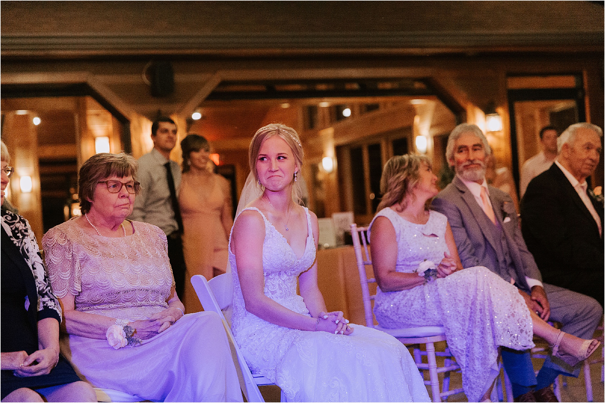 bride watches groom play guitar at wedding reception