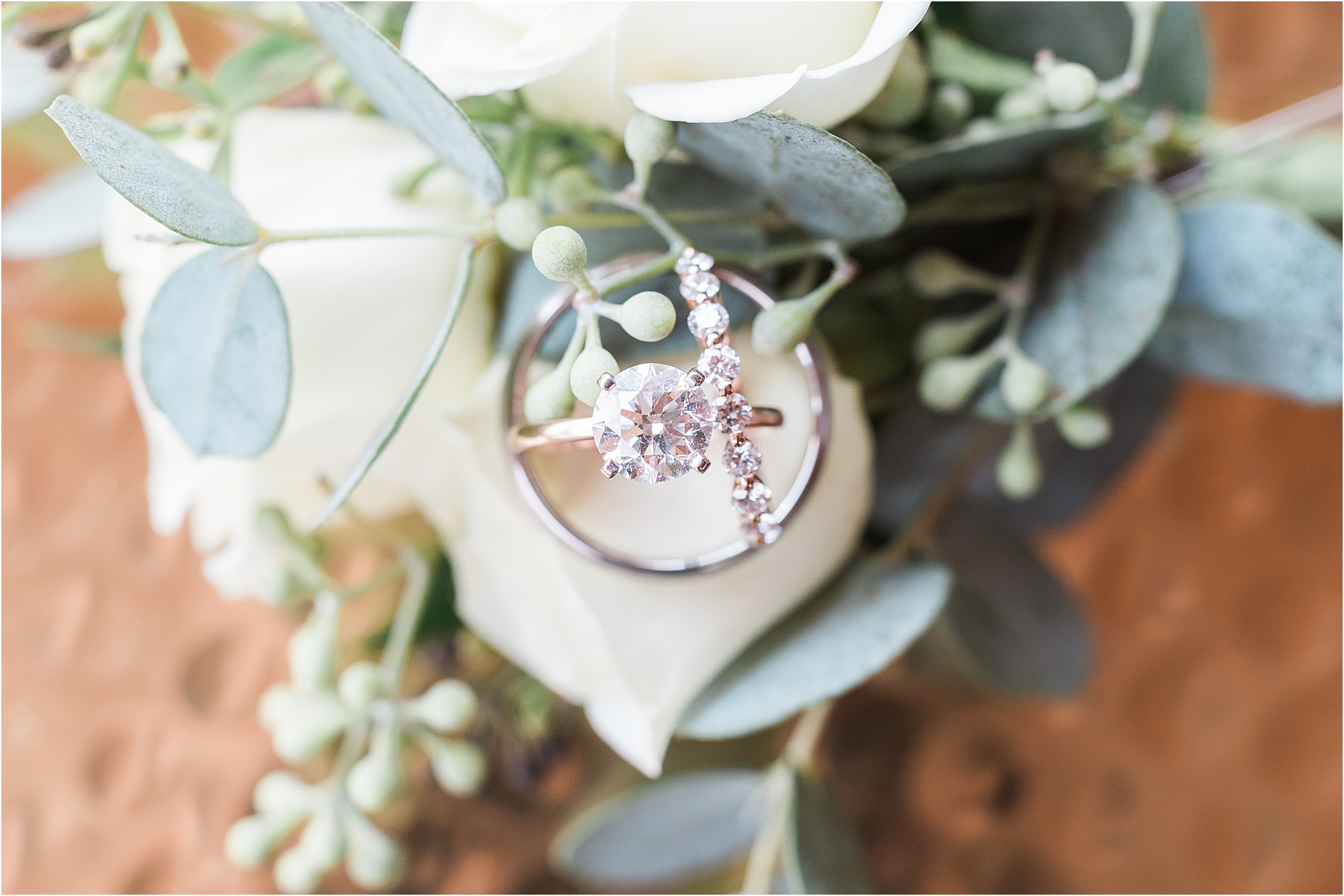 wedding rings surrounded by greenery