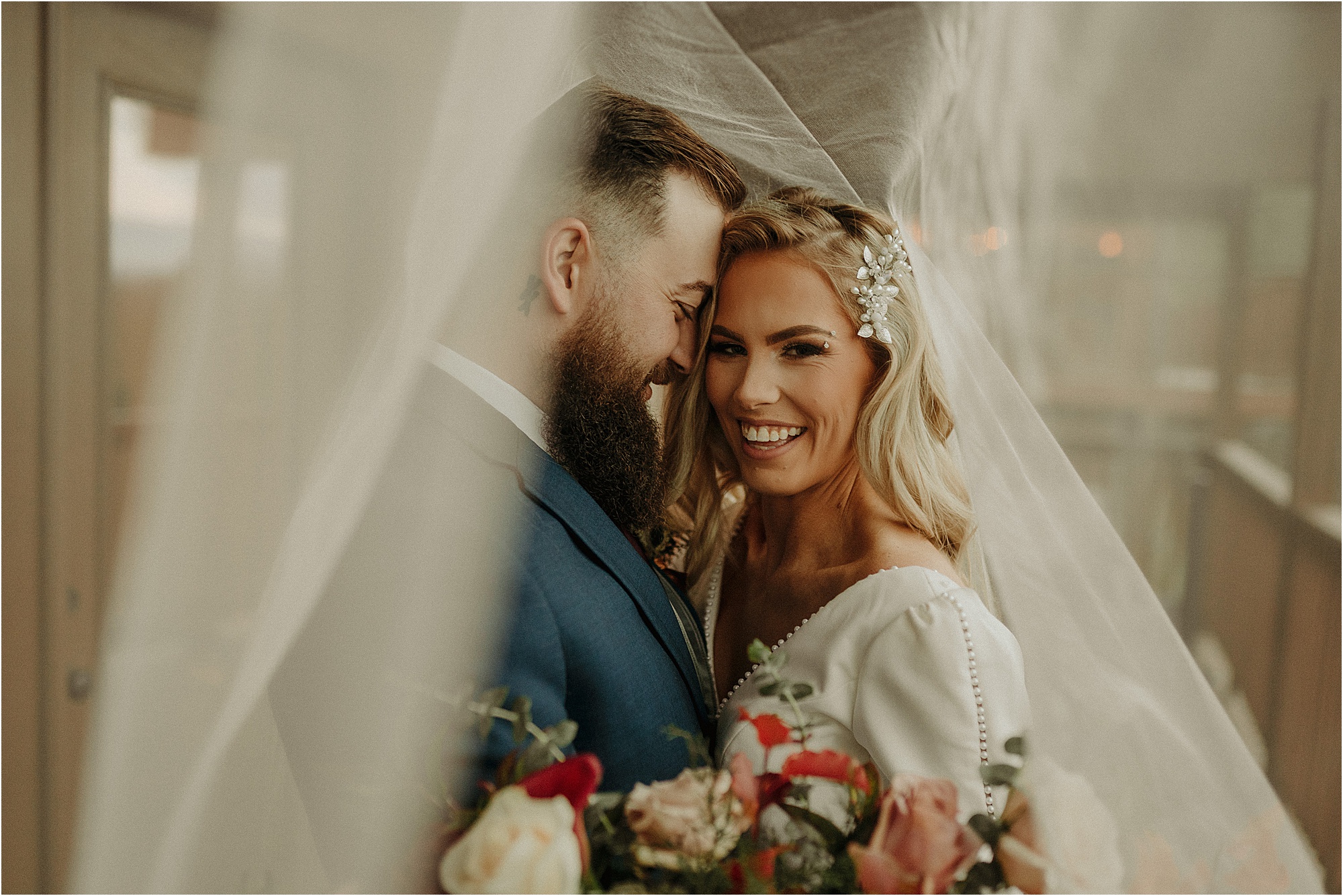 bride and groom underneath veil photo