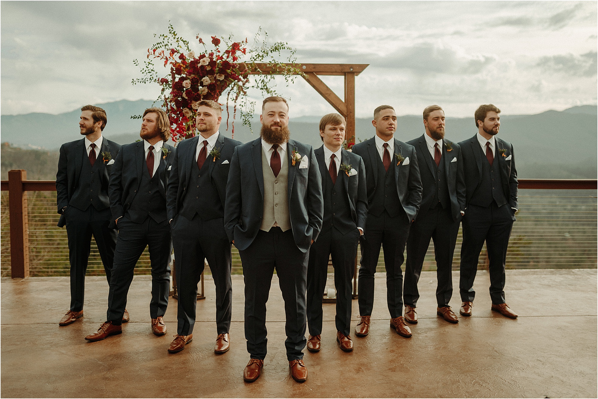 groom and groomsmen in blue sits and burgundy ties