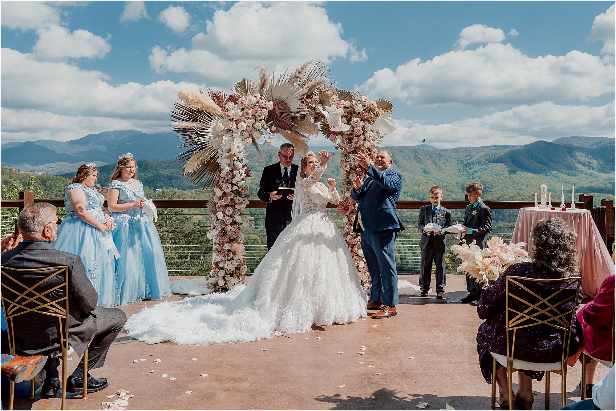 bride and groom wedding under dried floral wedding arch