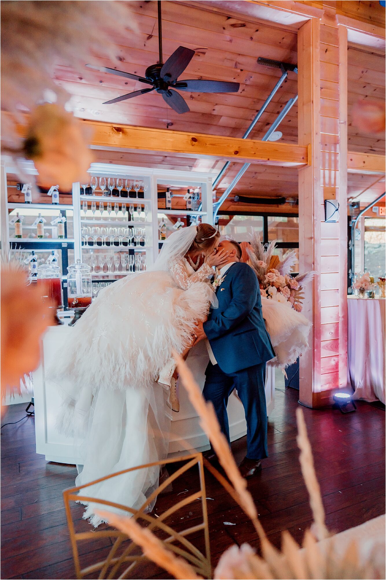 bride and groom kiss on bar top