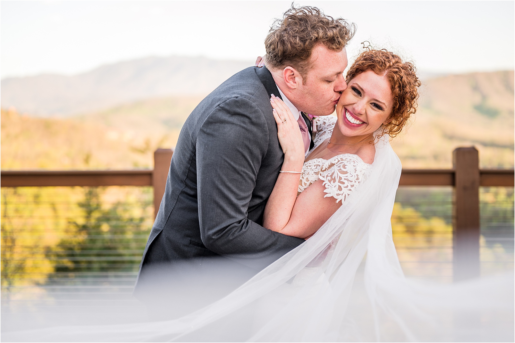 groom kisses bride on cheek as he dips her backwards