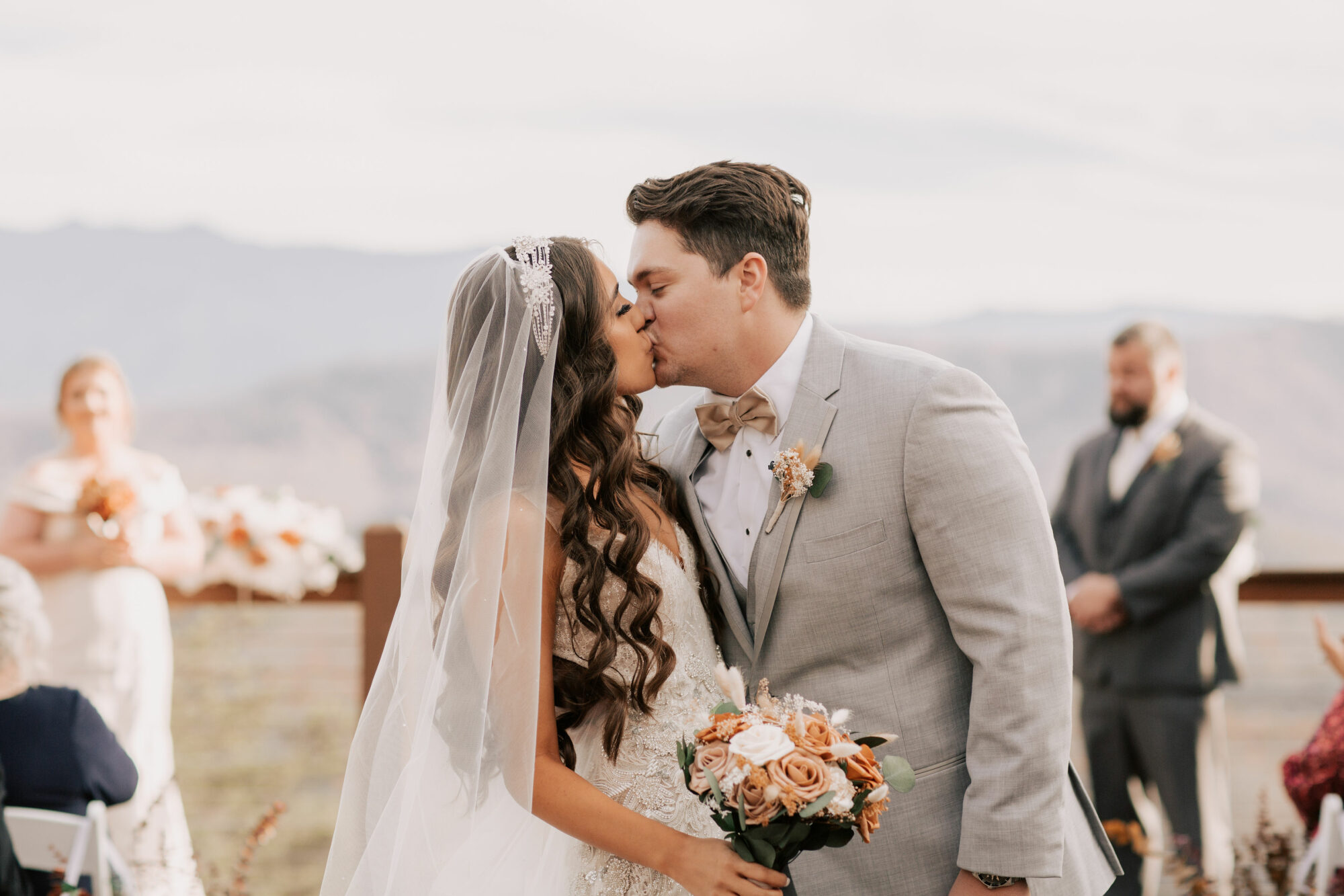 bride and groom first kiss in outdoor wedding