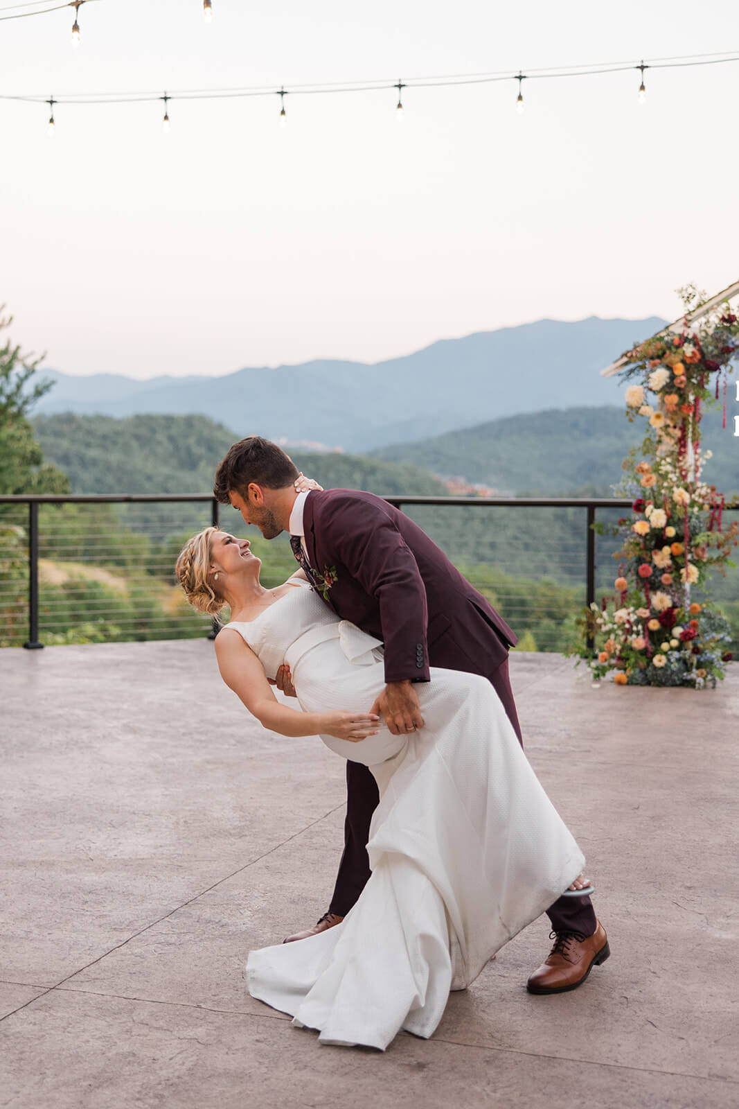 Evening reception under twinkling lights at The Magnolia Venue, couple dances their first dance at a luxury Smoky Mountain wedding venue